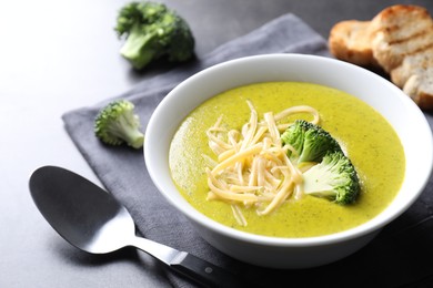 Photo of Delicious broccoli cream soup served on gray table, closeup