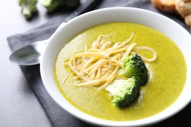 Photo of Delicious broccoli cream soup served on gray table, closeup