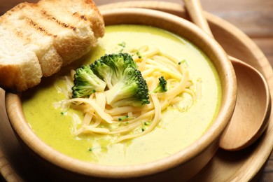 Photo of Delicious broccoli cream soup served on table, closeup