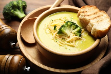 Photo of Delicious broccoli cream soup served on table, closeup