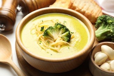 Photo of Delicious broccoli cream soup served on table, closeup