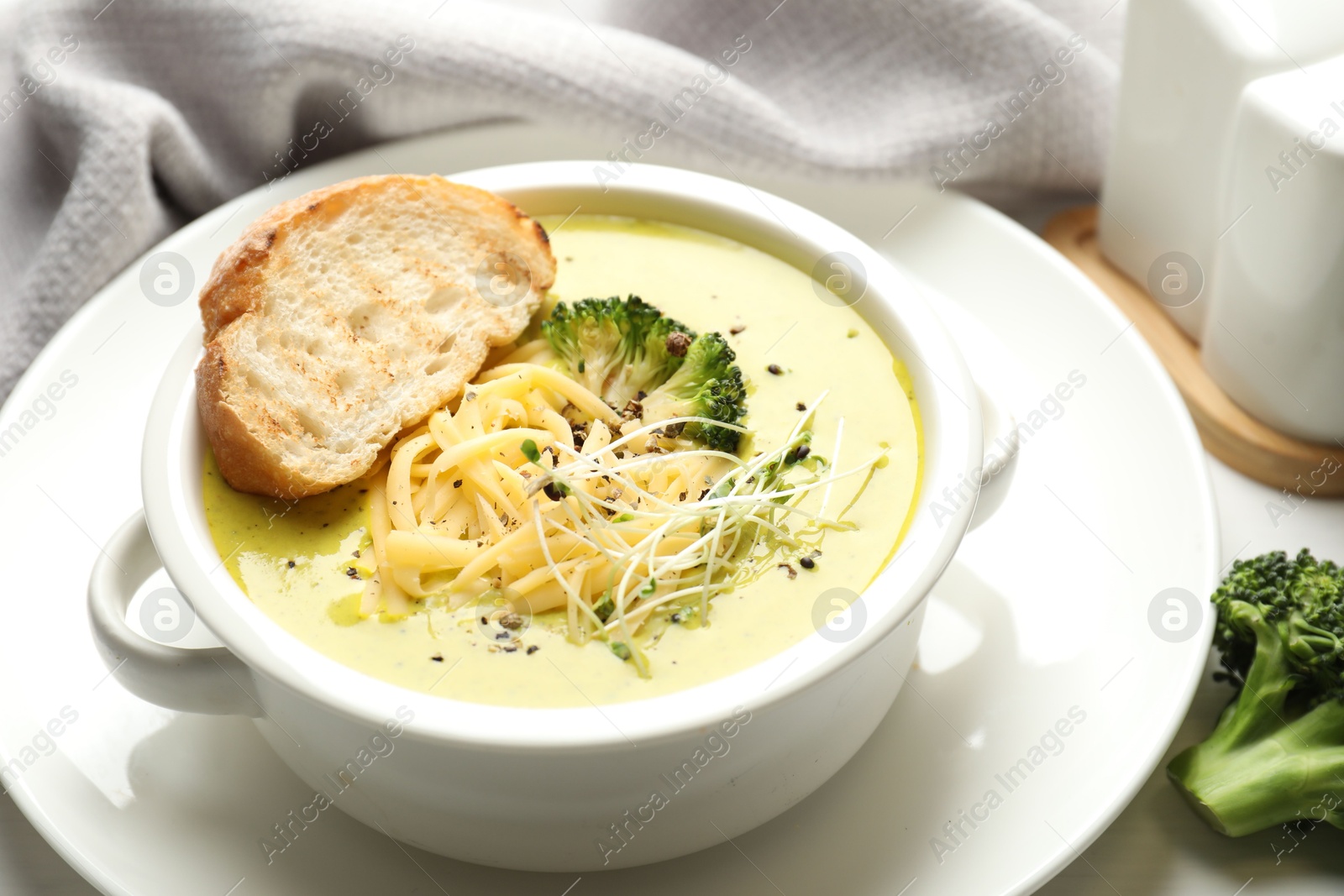 Photo of Delicious broccoli cream soup served on table, closeup