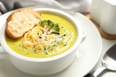 Photo of Delicious broccoli cream soup served on table, closeup