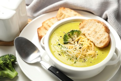 Photo of Delicious broccoli cream soup served on table, closeup