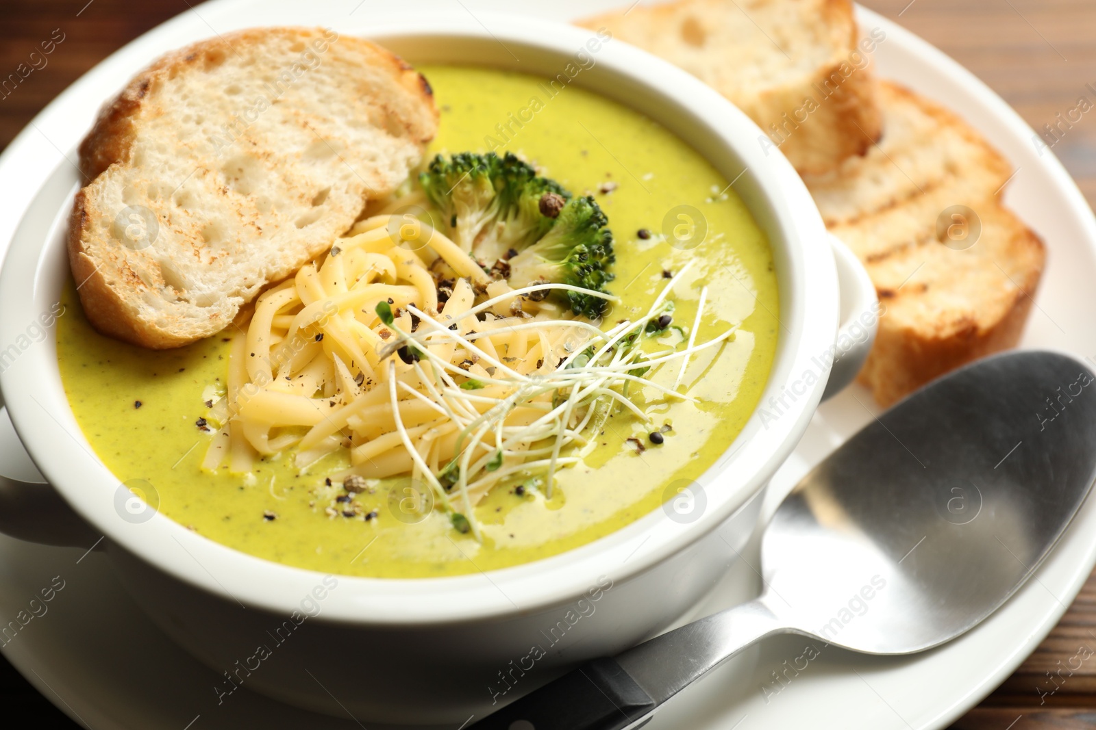 Photo of Delicious broccoli cream soup served on table, closeup