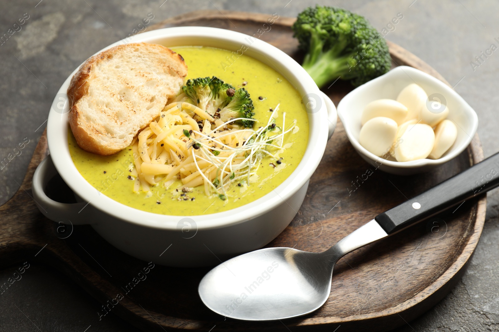 Photo of Delicious broccoli cream soup served on gray table, closeup