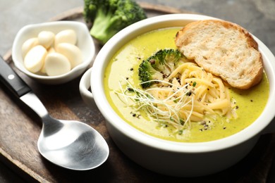 Photo of Delicious broccoli cream soup served on gray table, closeup