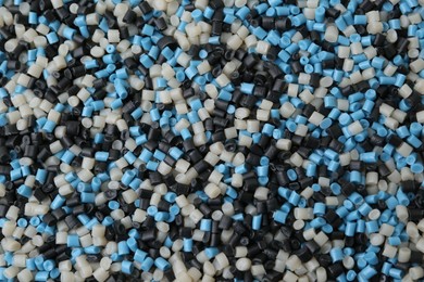 Photo of Pile of colorful plastic granules as background, top view