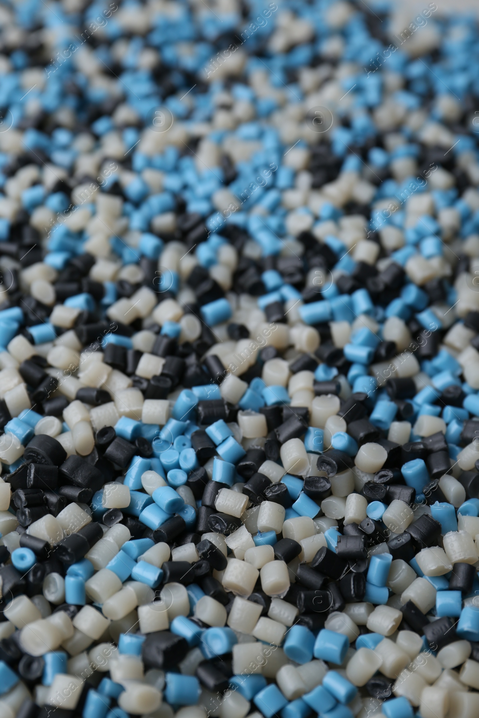 Photo of Pile of colorful plastic granules as background, closeup