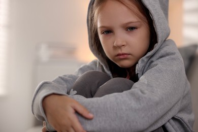 Photo of Orphanage concept. Portrait of sad girl in room