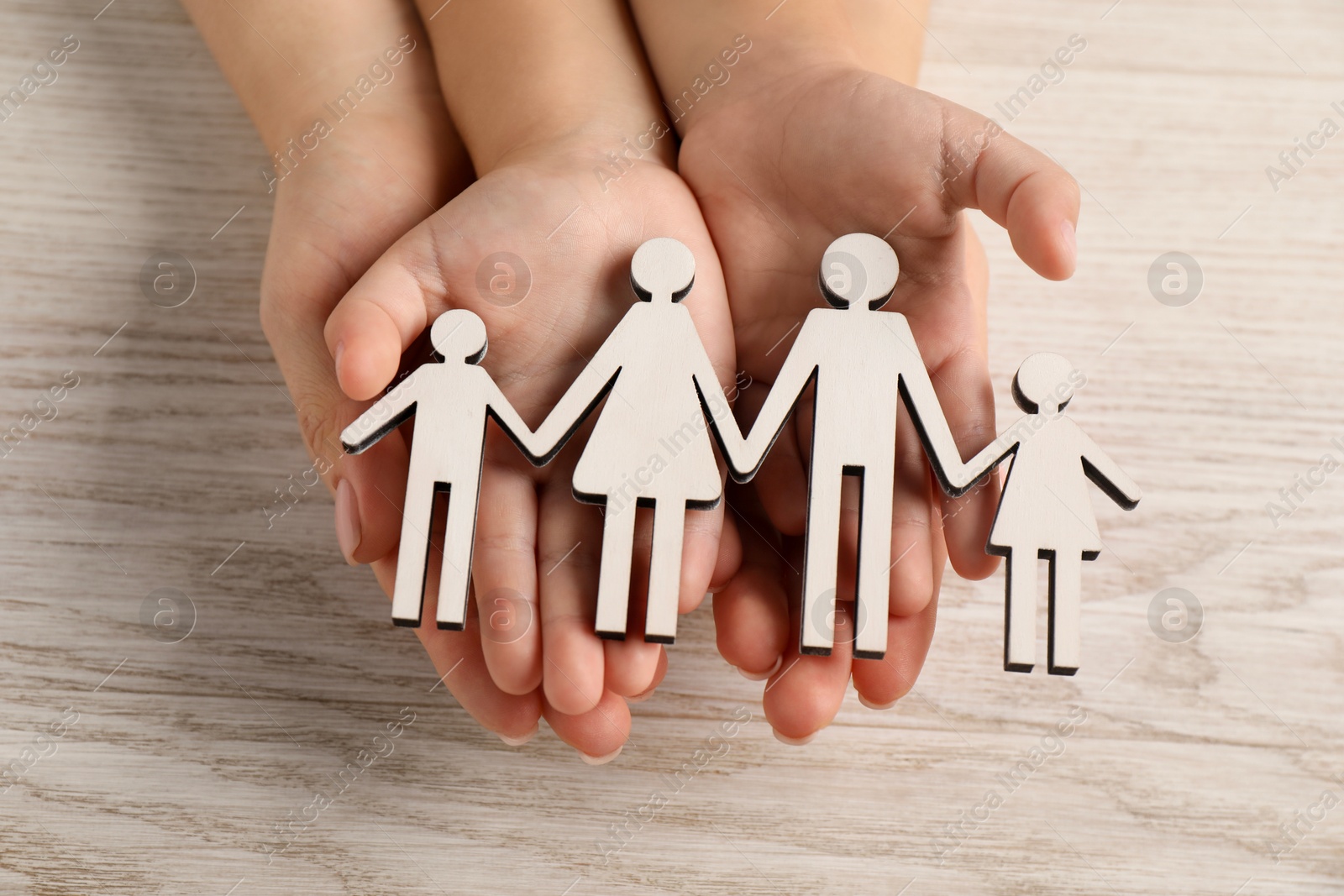 Photo of Adoption concept. Woman and kid with cutout of family at white wooden table, top view