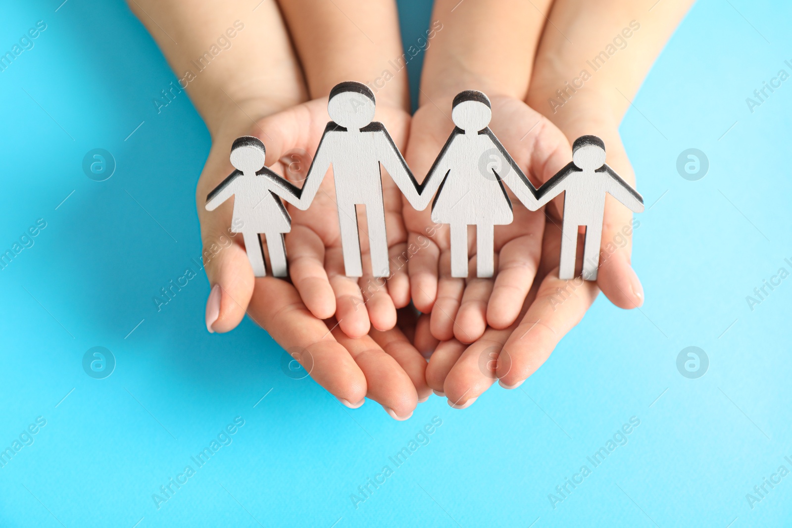 Photo of Adoption concept. Woman and kid with cutout of family at light blue background, closeup