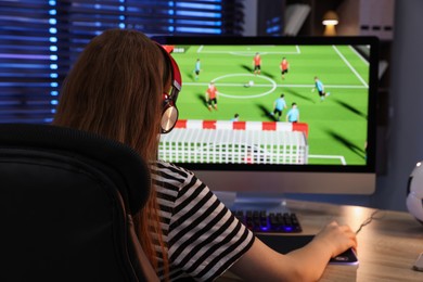 Photo of Girl playing video game at table indoors, back view