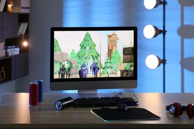 Photo of Computer keyboard, monitor, cans, headphones and mouse on table indoors