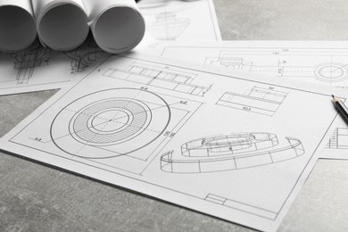 Photo of Different engineering drawings on gray textured table, closeup