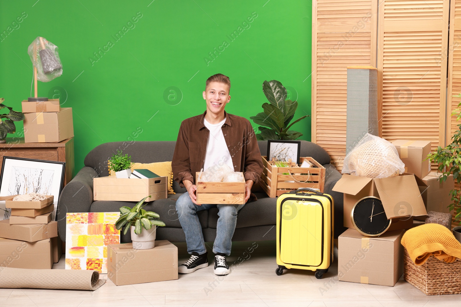 Photo of Happy man with different stuff in new apartment. Housewarming party