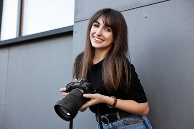 Professional photographer with digital camera near building outdoors