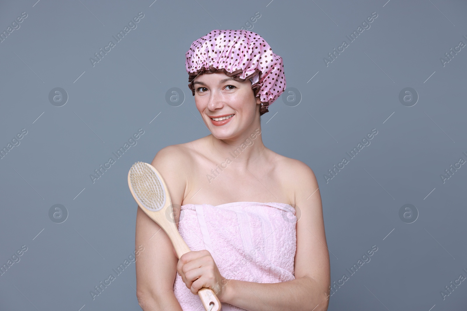 Photo of Woman with shower cap and brush on grey background