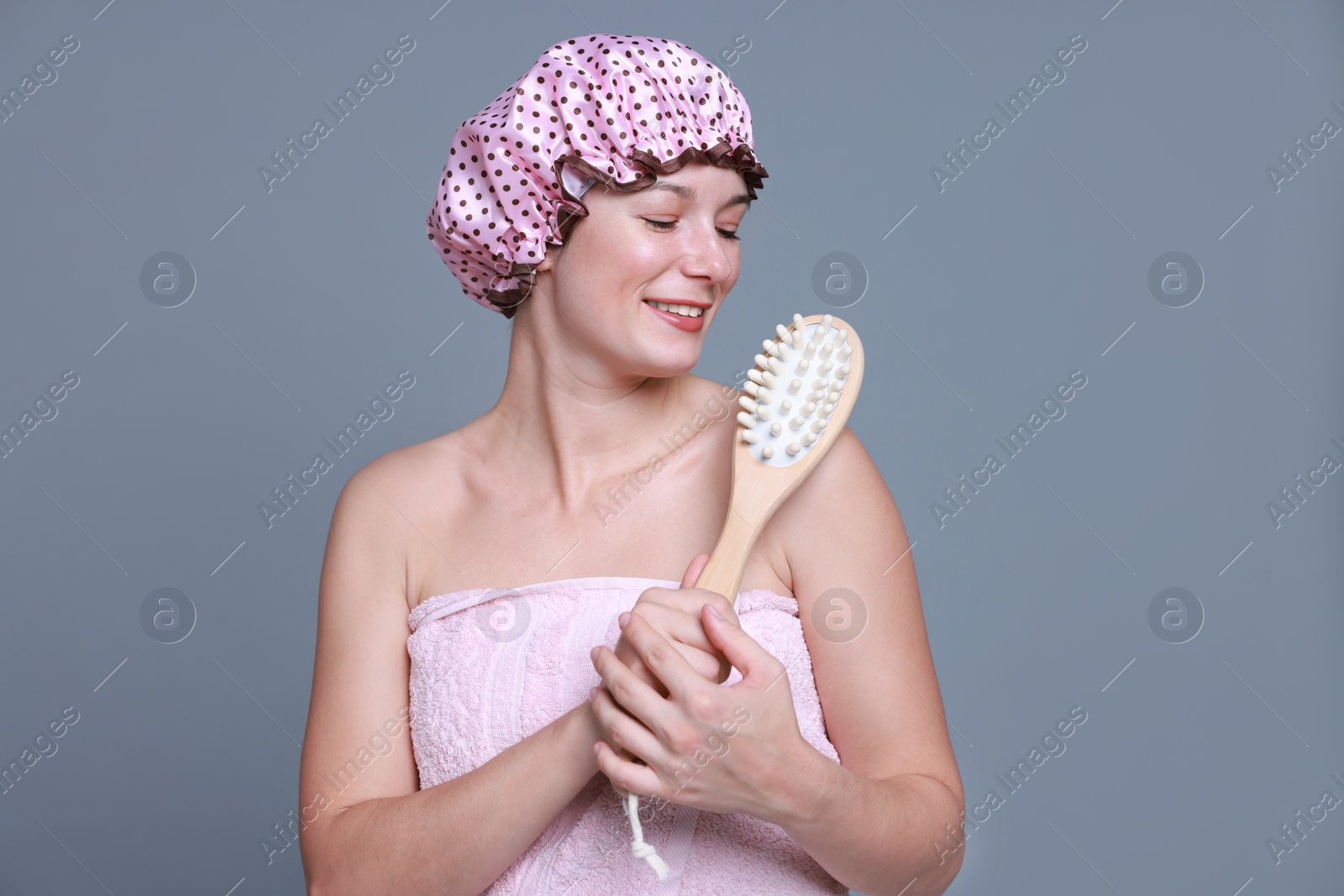 Photo of Woman with shower cap and brush on grey background