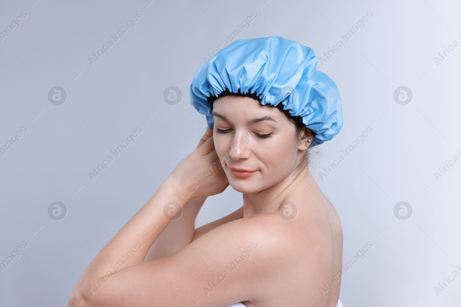 Photo of Woman wearing shower cap on grey background