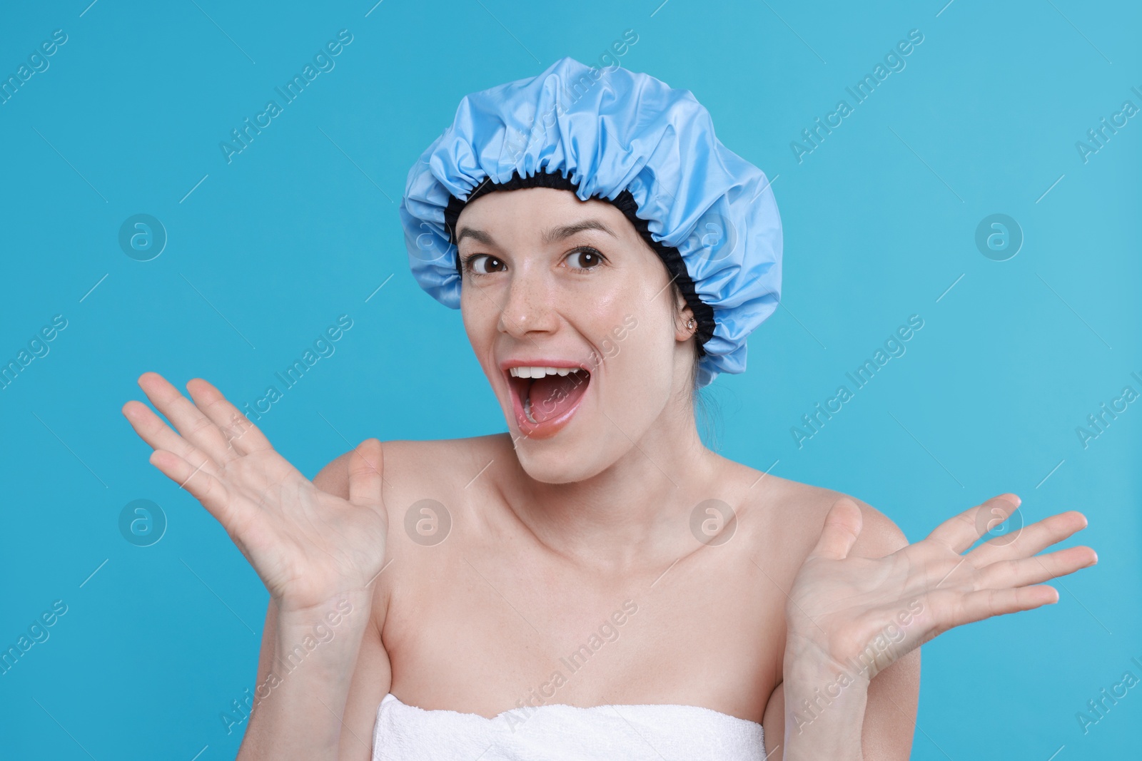 Photo of Emotional woman in shower cap on light blue background