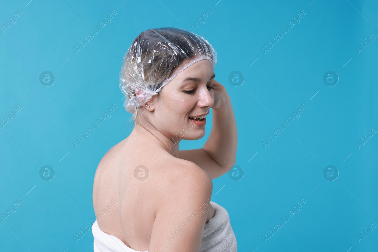 Photo of Woman in shower cap on light blue background