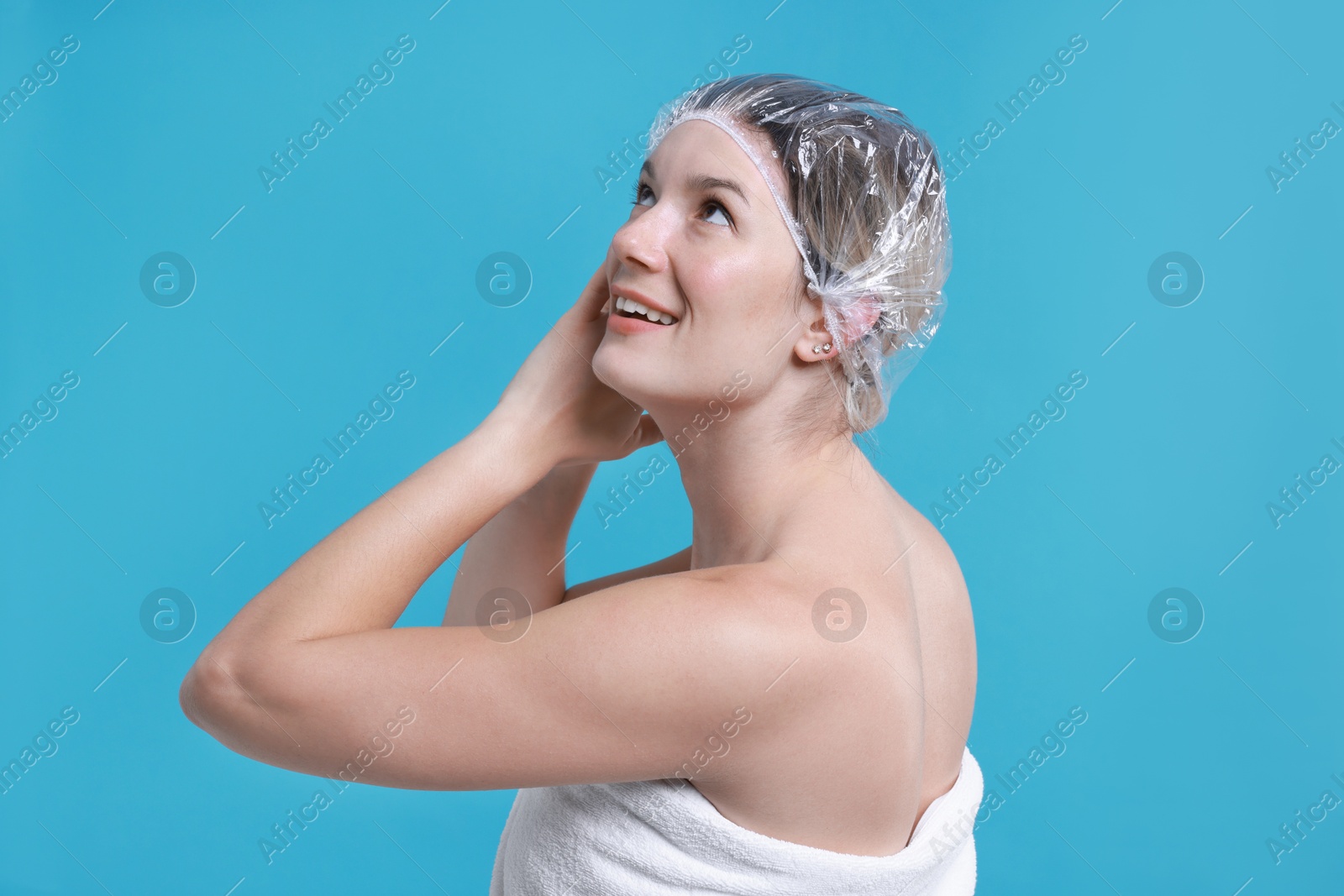 Photo of Woman in shower cap on light blue background