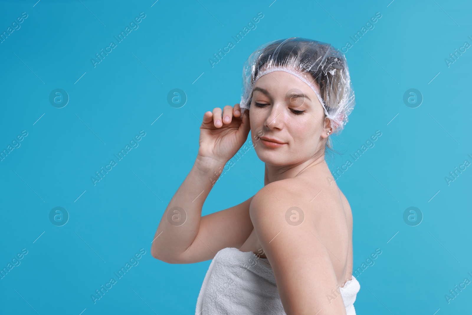 Photo of Woman in shower cap on light blue background