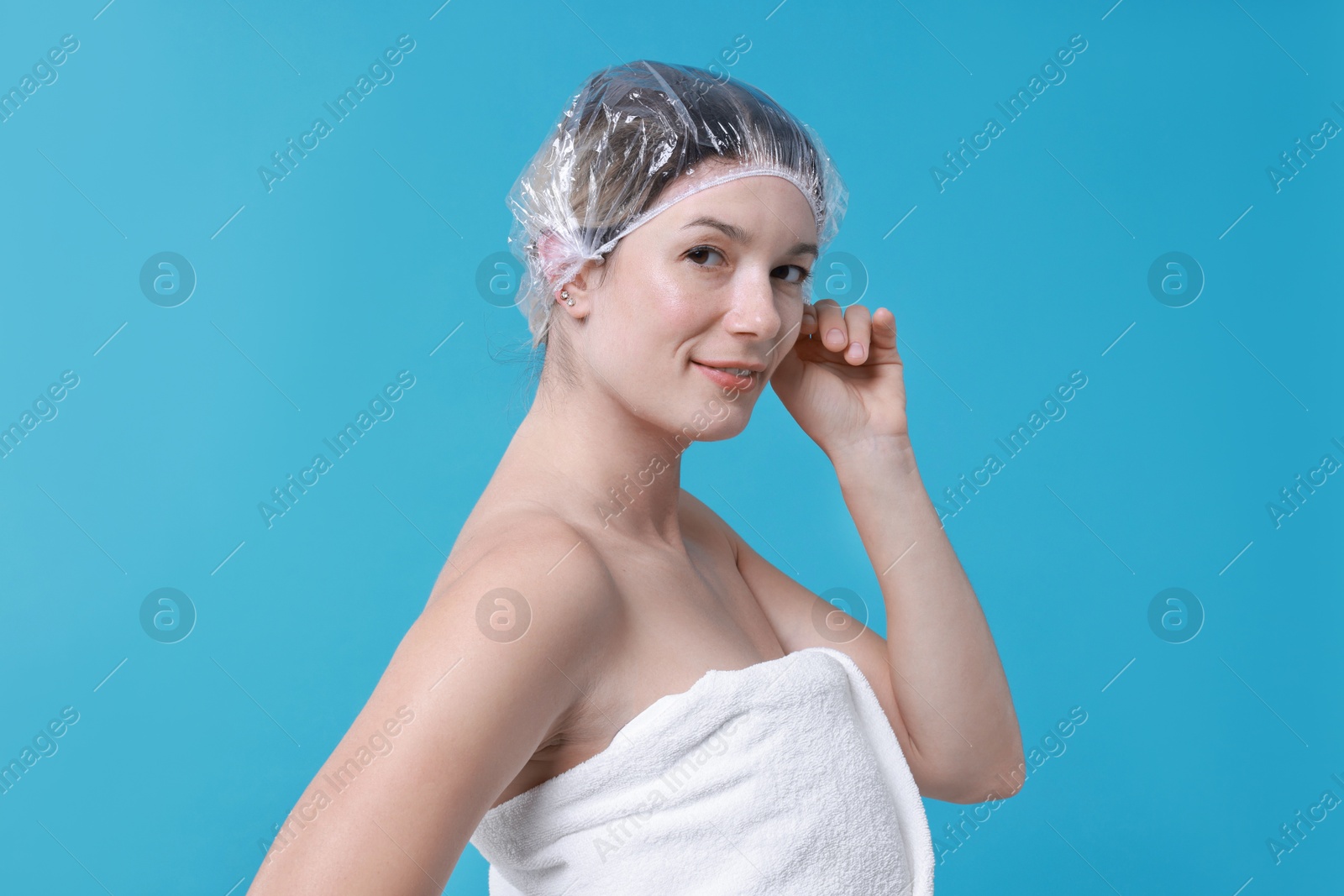 Photo of Woman in shower cap on light blue background