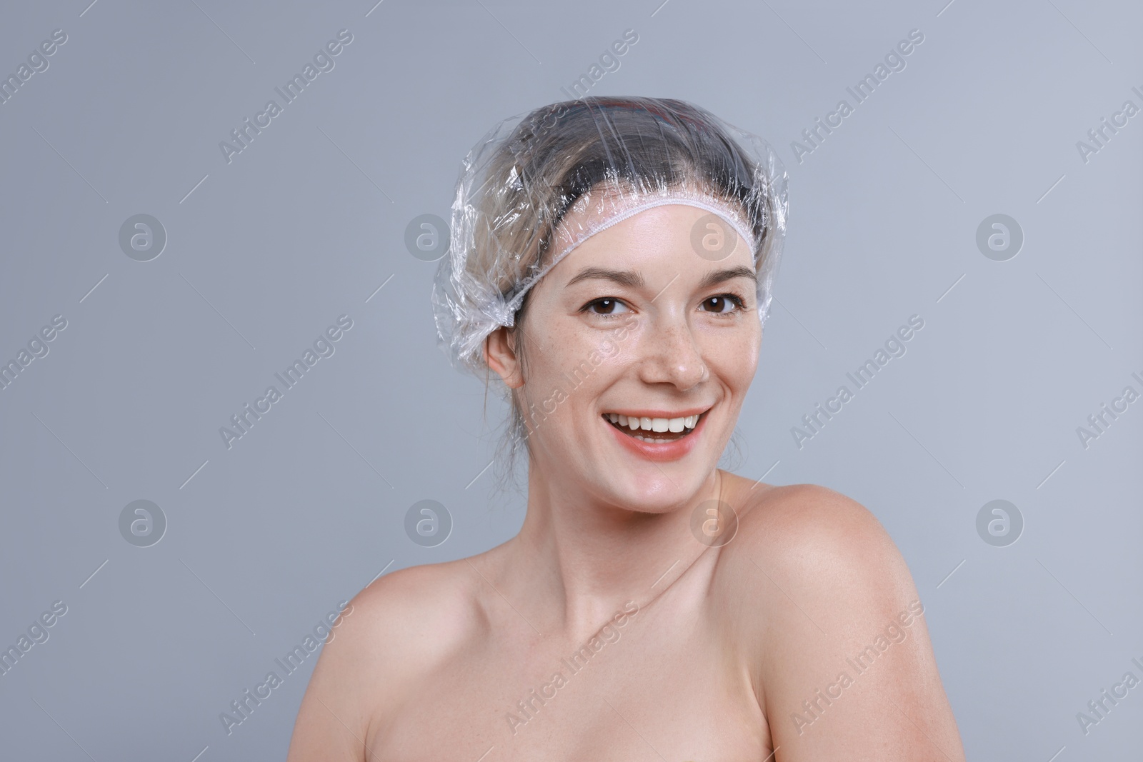 Photo of Woman in shower cap on grey background