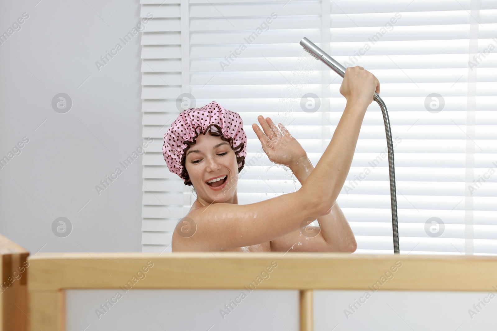 Photo of Woman with cap taking shower in bathroom