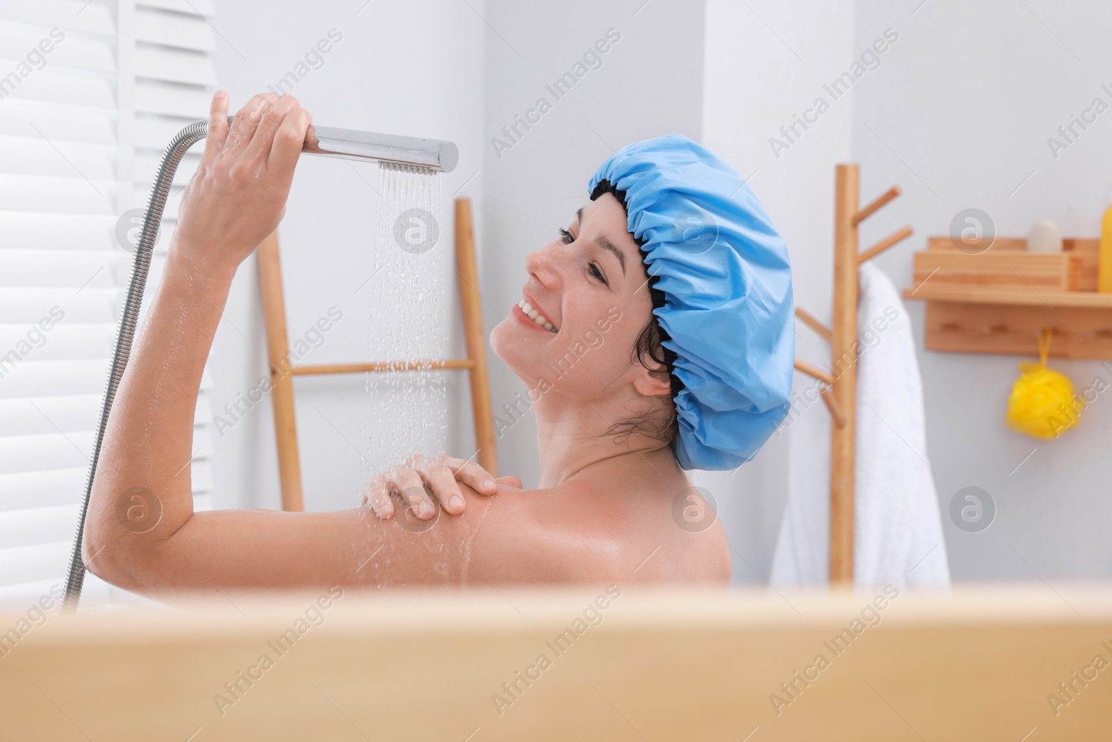 Photo of Woman with cap taking shower in bathroom