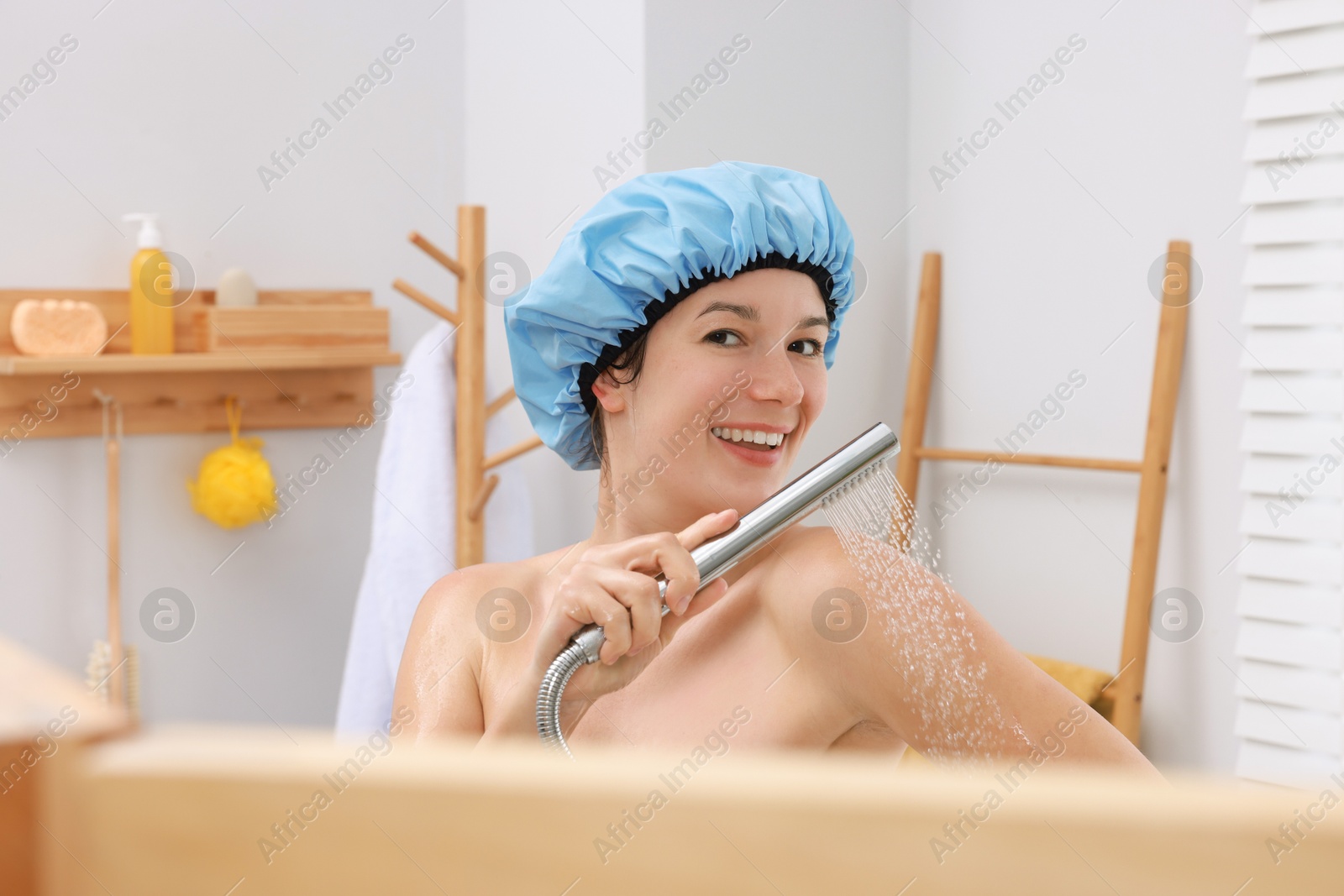 Photo of Woman with cap taking shower in bathroom