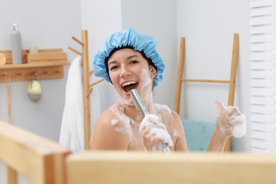 Photo of Woman with cap singing while taking shower in bathroom