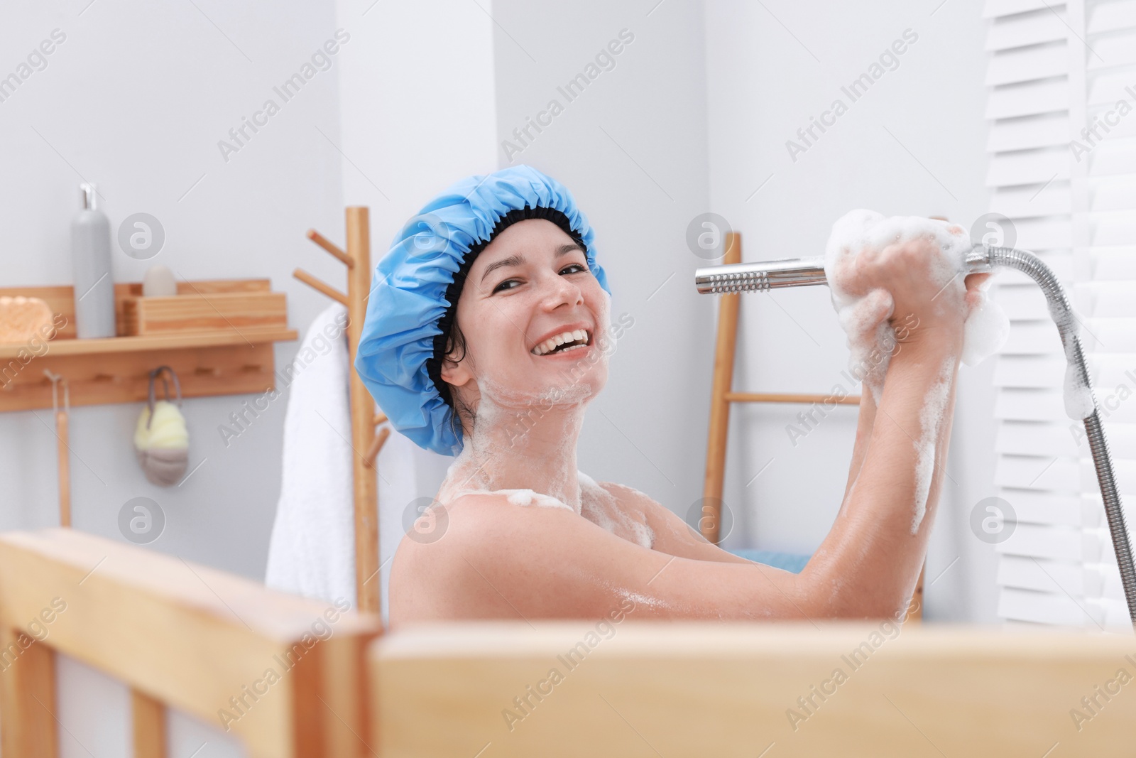 Photo of Woman with cap singing while taking shower in bathroom