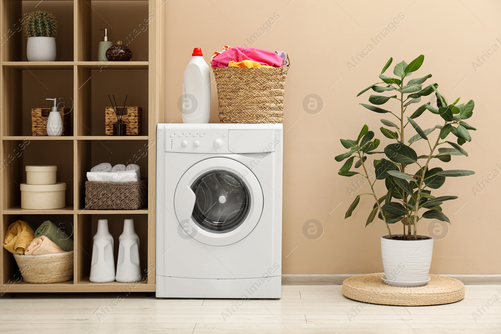 Photo of Wicker basket full of laundry, washing machine and detergent in bathroom