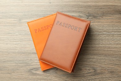 Photo of Passports in color covers on wooden table, top view