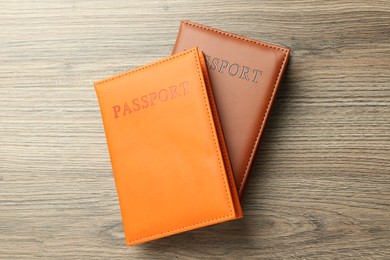 Photo of Passports in color covers on wooden table, top view