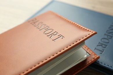 Photo of Passports in color covers on table, closeup