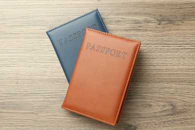 Photo of Passports in color covers on wooden table, top view