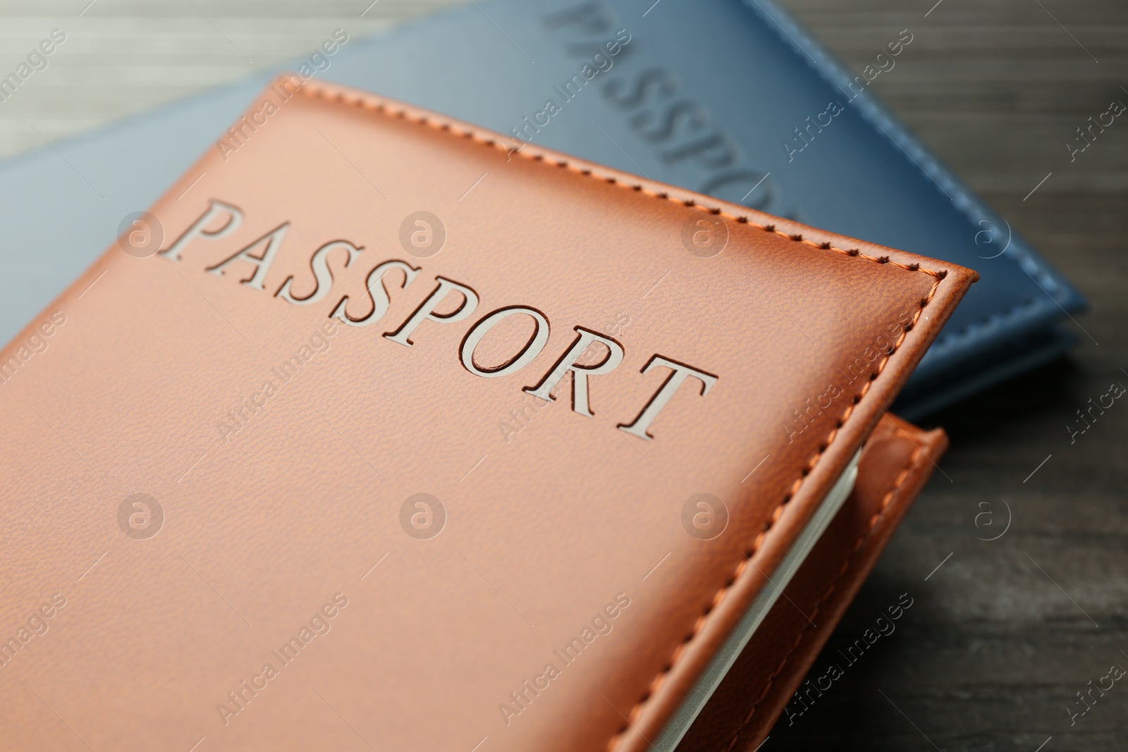 Photo of Passports in color covers on table, closeup