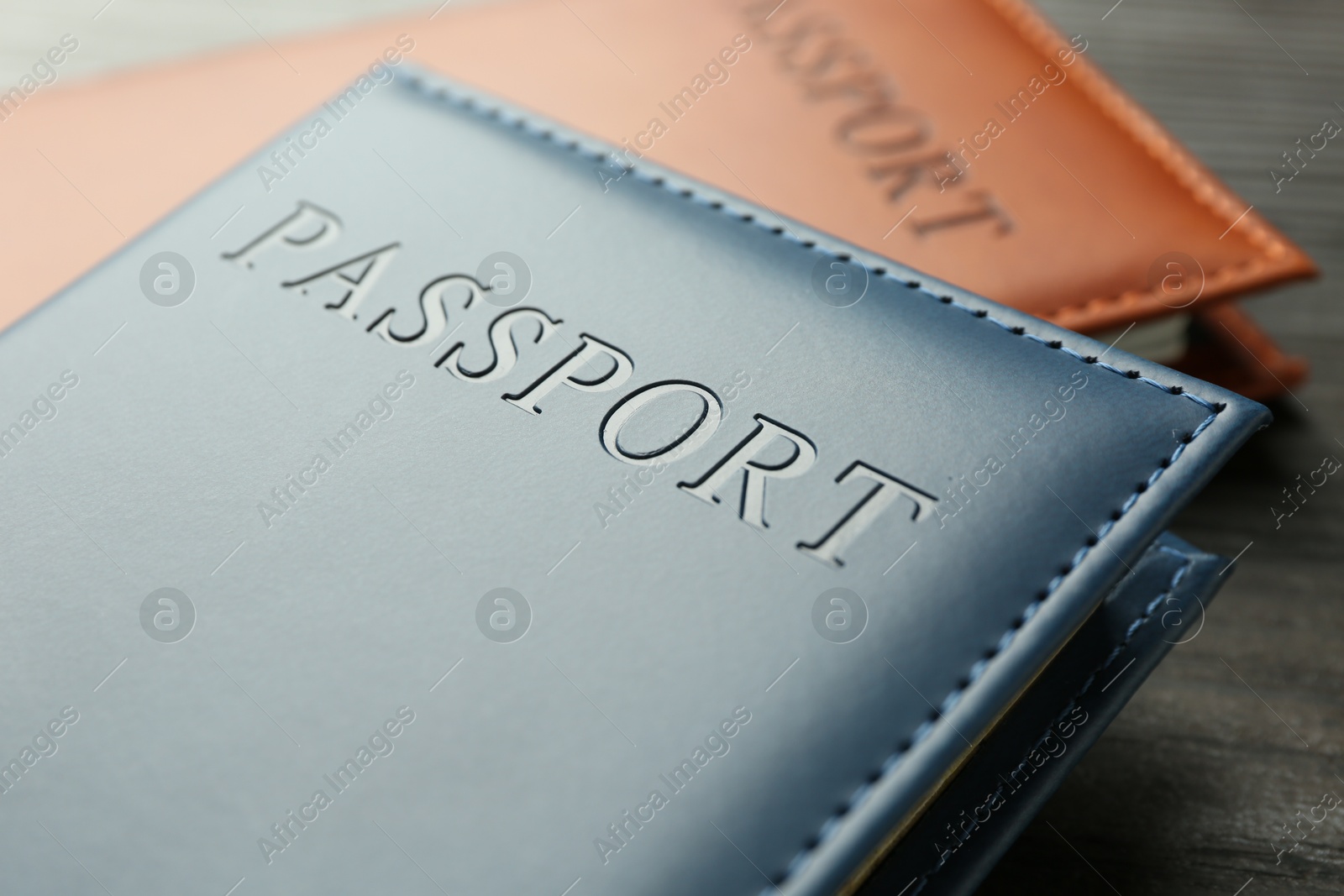 Photo of Passports in color covers on table, closeup