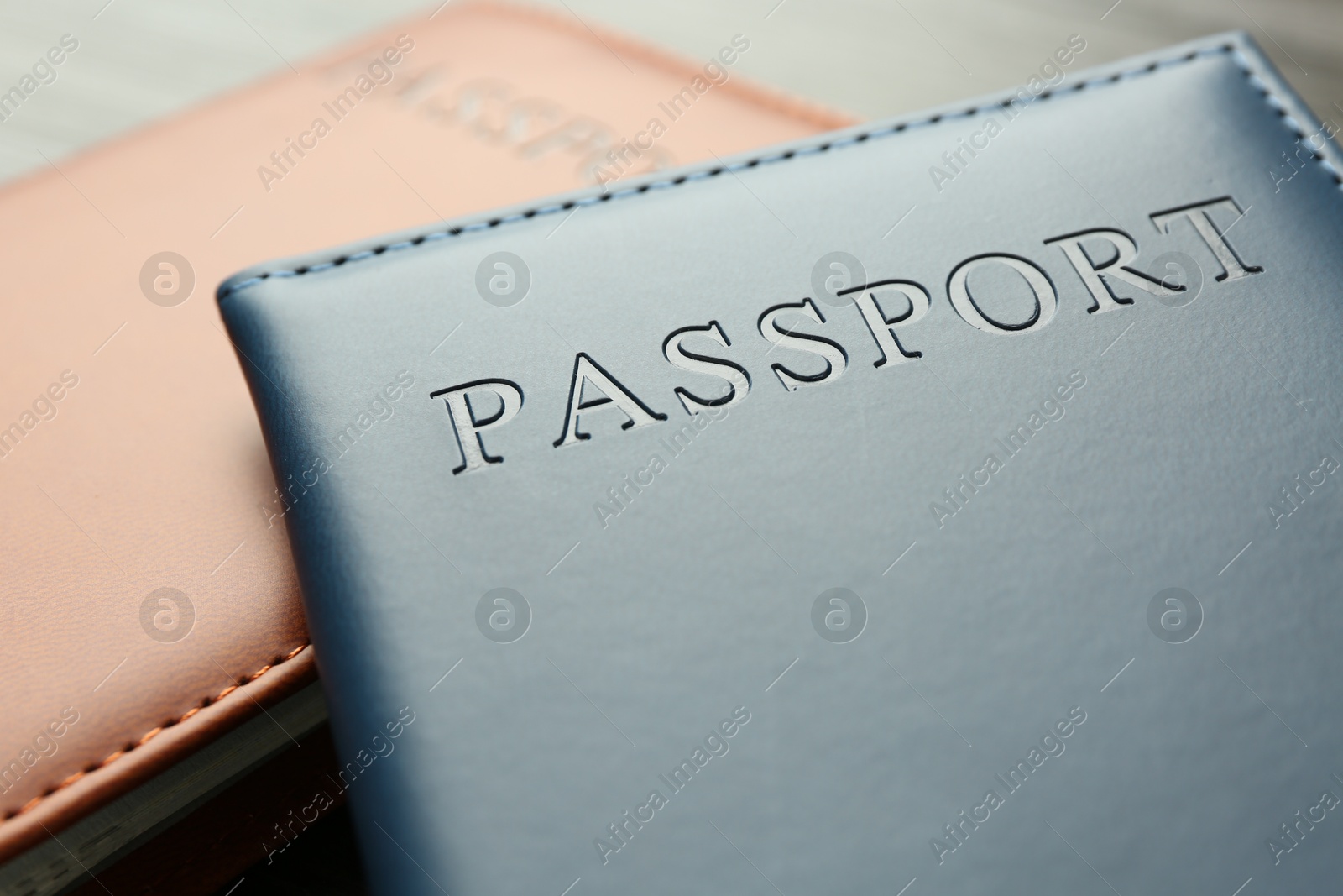 Photo of Passports in color covers on table, closeup