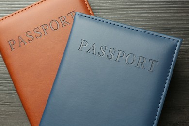 Photo of Passports in color covers on wooden table, top view