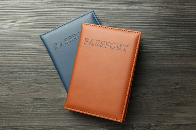 Photo of Passports in color covers on wooden table, top view