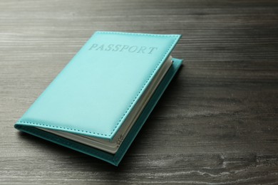 Photo of Passport in light blue cover on wooden table, closeup