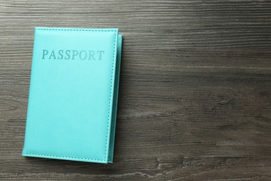 Photo of Passport in light blue cover on wooden table, top view. Space for text