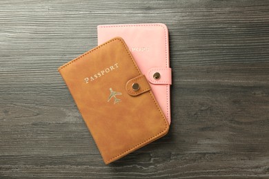 Photo of Passports in color covers on wooden table, top view