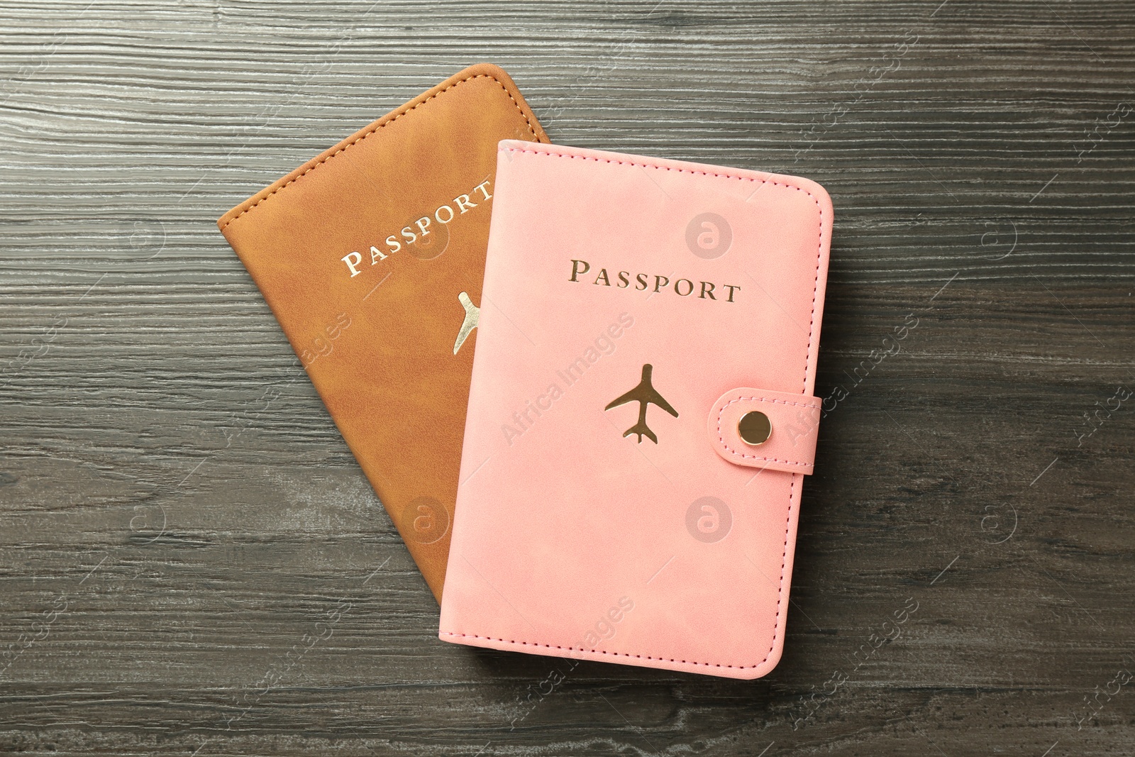 Photo of Passports in color covers on wooden table, top view