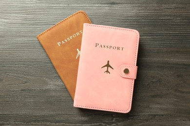 Photo of Passports in color covers on wooden table, top view